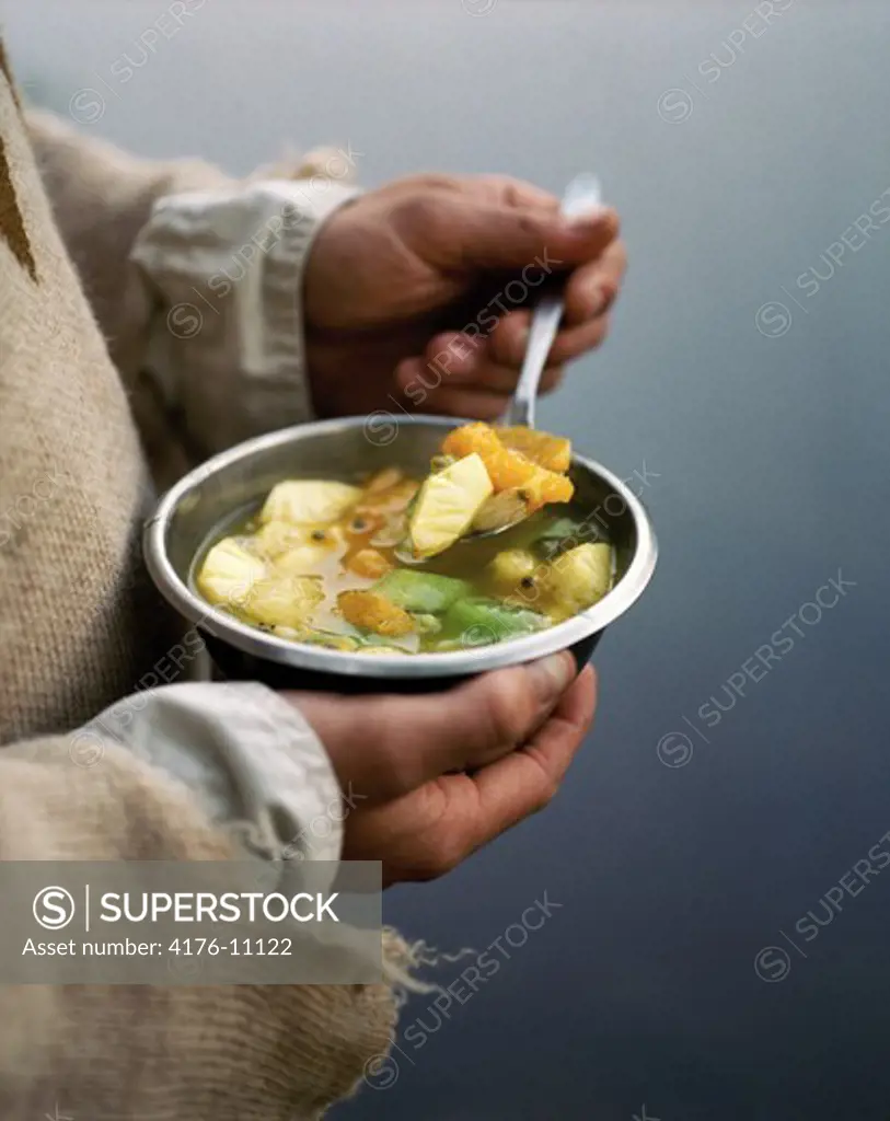 A person holding bowl of food