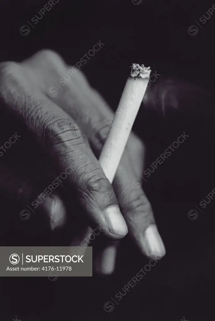 Close-up of a man's hand holding a cigarette