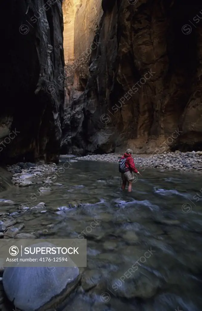 A hiker crossing the river in Utah, USA