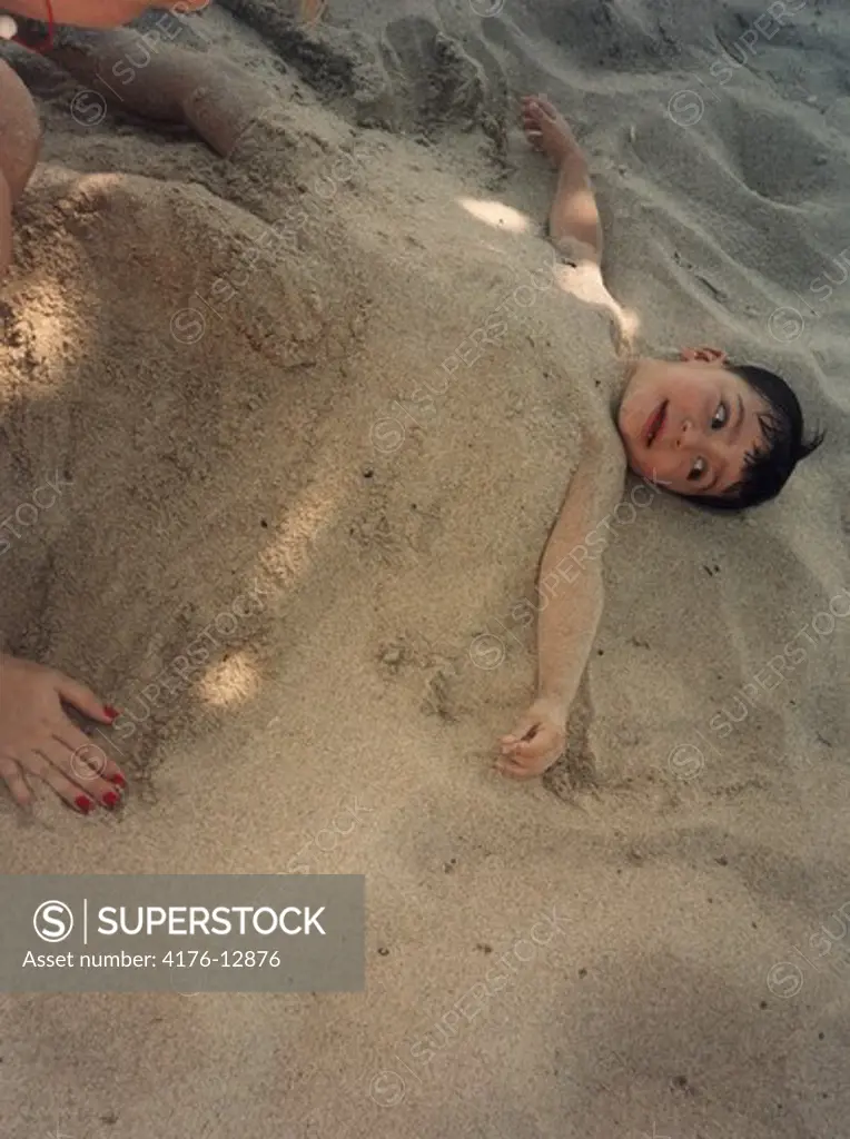 A boy buried in sand