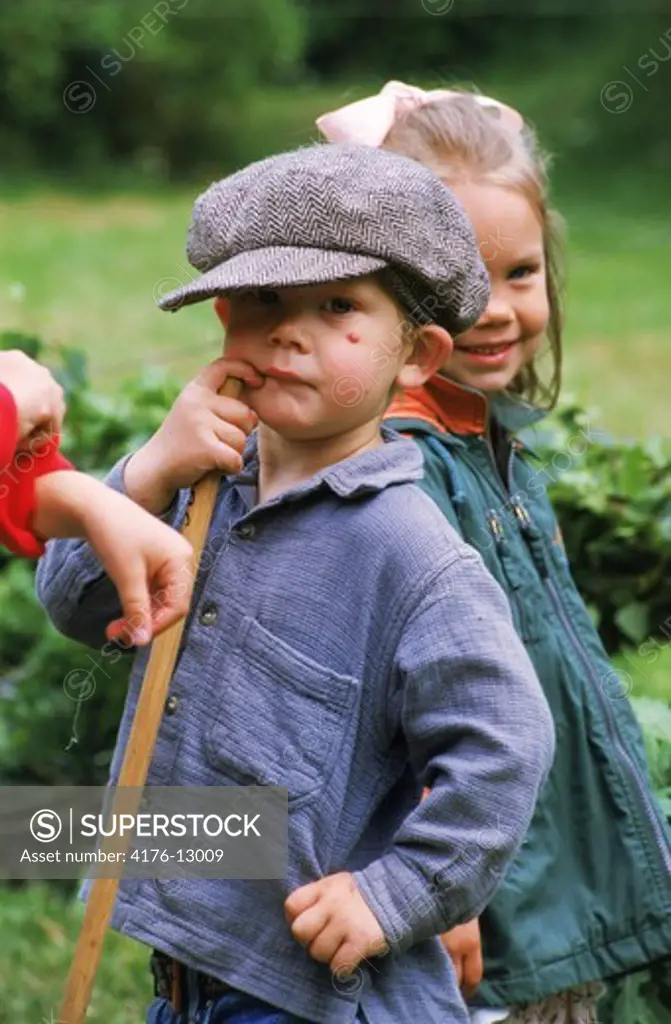 Boy with hat playing with mates outdoors