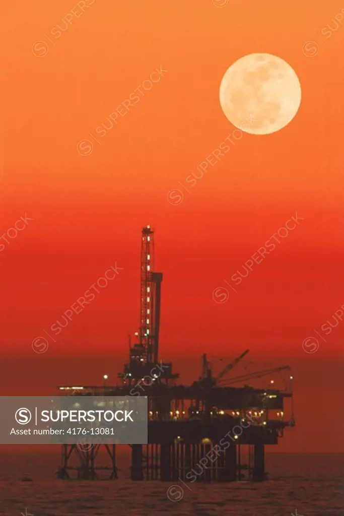 Offshore oil rig under full moon at Huntington Beach California