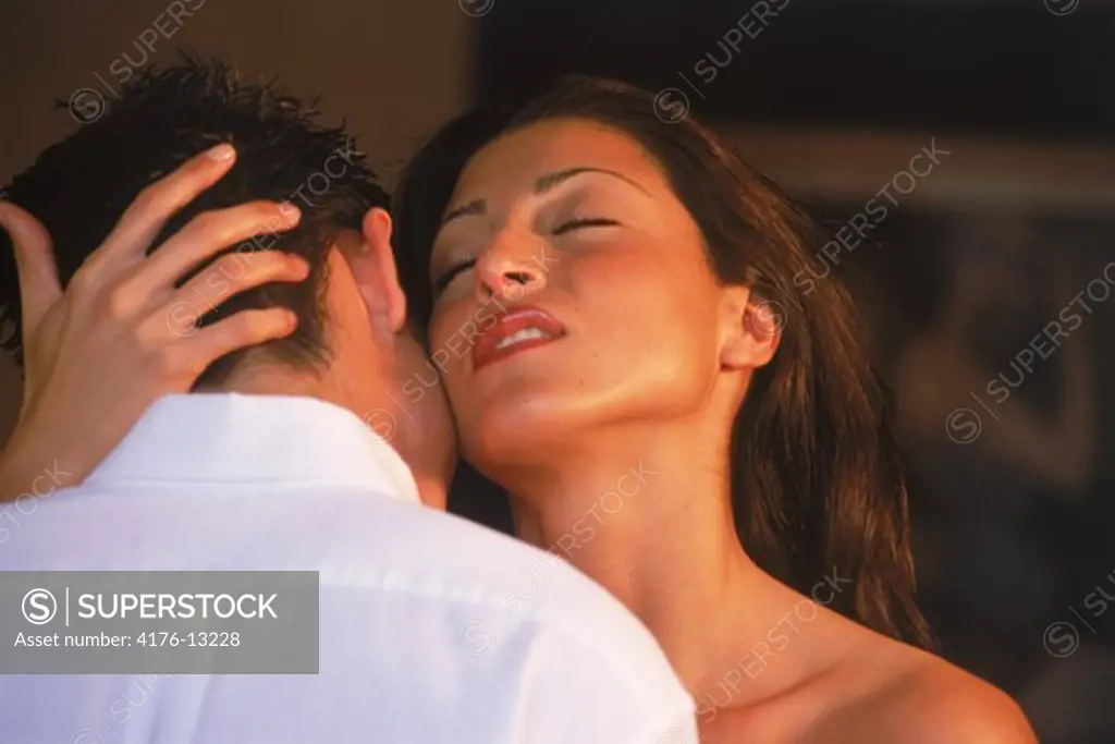 Hispanic woman caressing Caucasion man