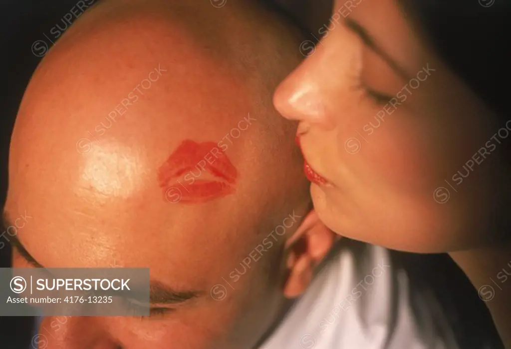 Hispanic woman kissing her mans shaved head