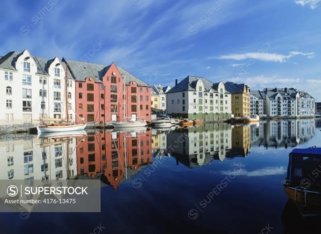 Houses and boats along canal at sunrise in Alesund, Norway