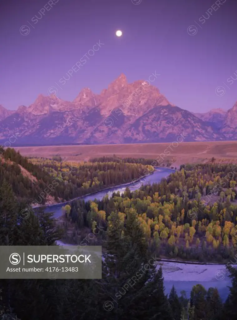 Moon over Mount Moran in Grand Tetons above Snake River at dawn near Jackson, Wyoming