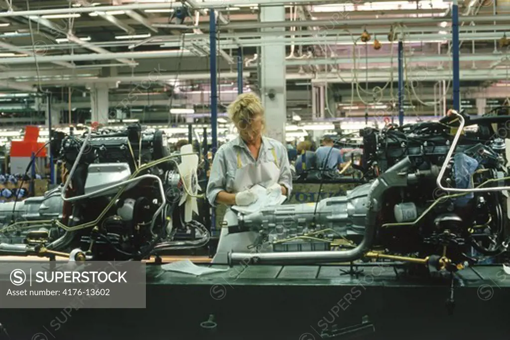 Woman working on engine assembly line at Volvo Torslanda Plant near Gothenburg, Sweden