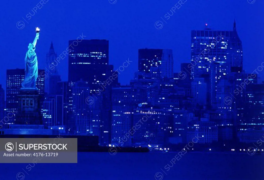 NIGHT TIME SKYLINE OF NEW YORK CITY AND STATUE OF LIBERTY