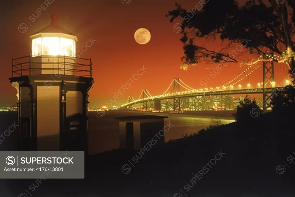 Yerba Buena Lighthouse on Yerba Buena Island with Bay Bridge and San Francisco skyline under full moon
