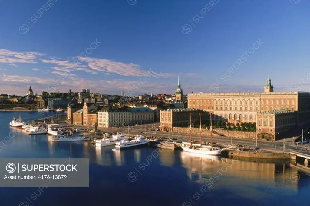 Boats anchored along Skeppsbron at sunrise with Royal Palace and Old Town in Stockholm