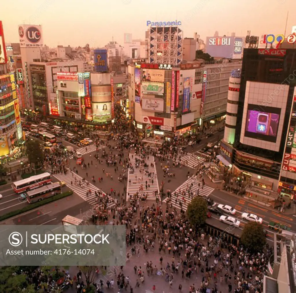 Overview of Shibuya district with pedistrian traffic and neon signs at dusk in Tokyo