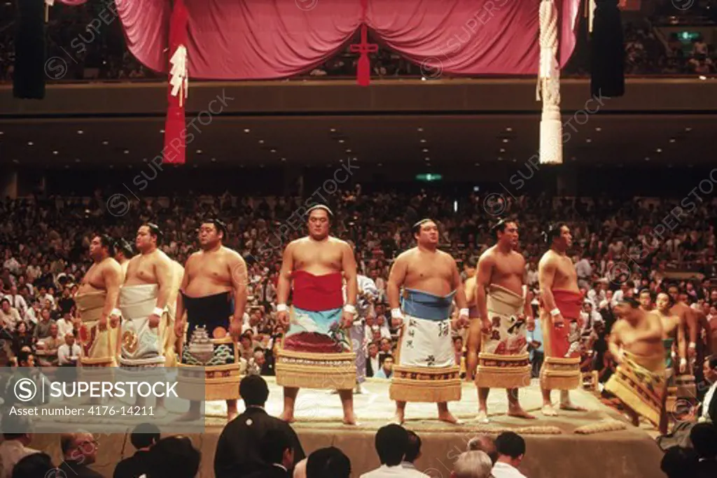 Pre fight sumo wrestling ceremony of  competitors parading around ring or dohyo in traditional costume