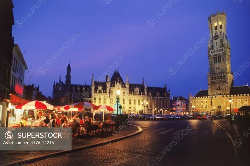 Market Square in Brugge with tall Cathedral belfry at night