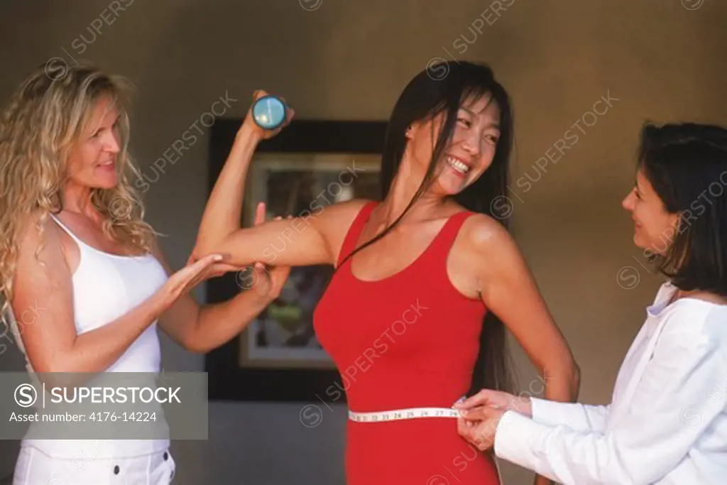 Three women of ethnic mix sharing health and fitness ideas in bedroom