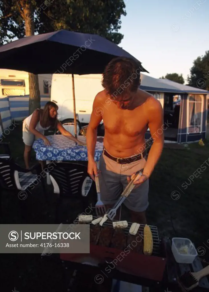Man barbequing in the lawn,camping
