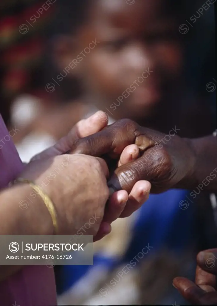 Close up view of interlinked hands of two people with diverse race