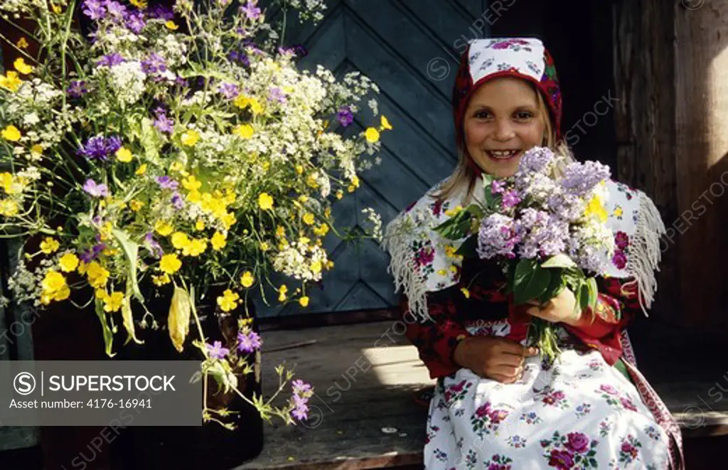 Girl smiling whilst holding a bunch of colourful flowers