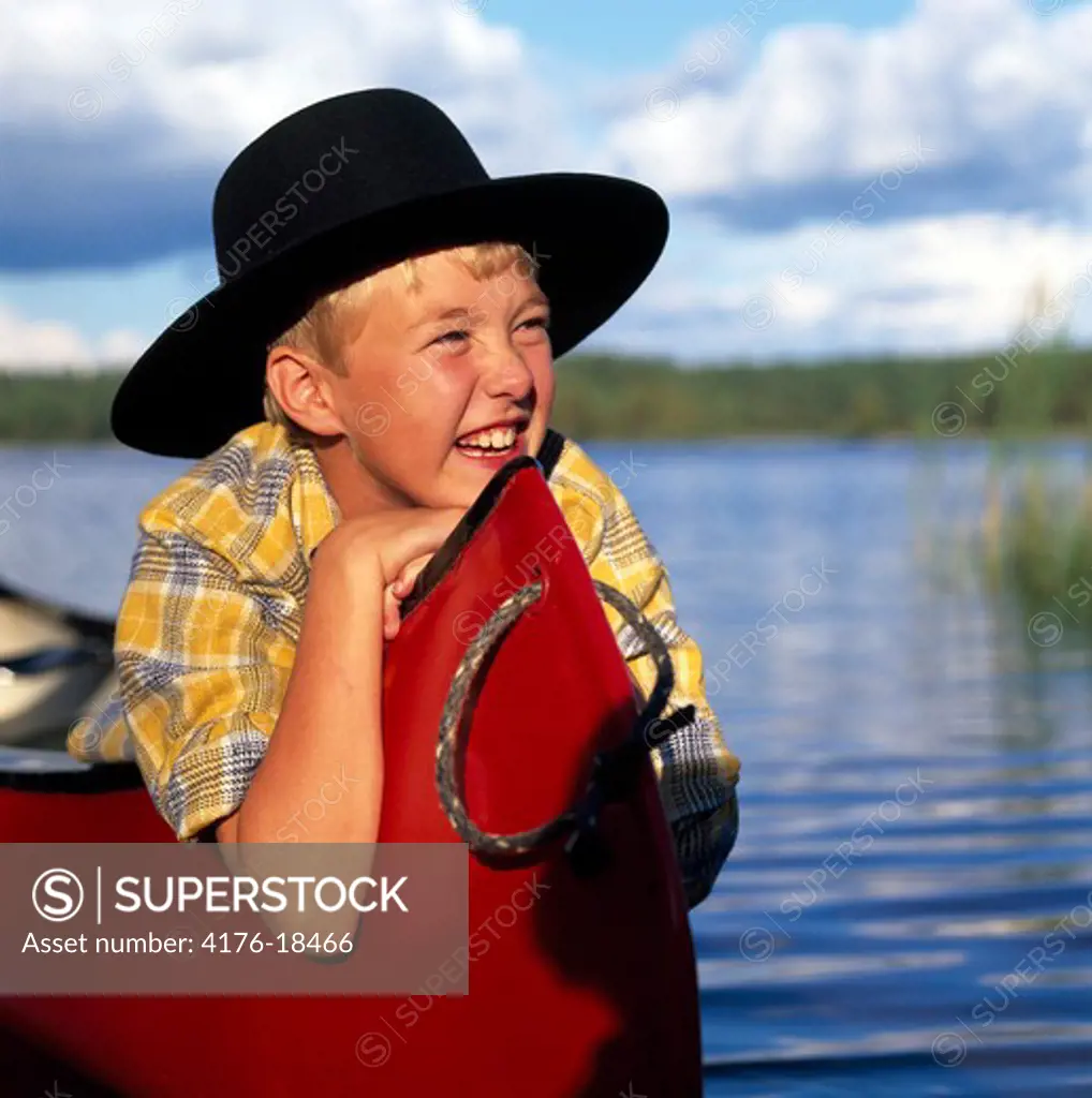 Close-up of a boy smiling, lake Jamnasjon in Vastra Gotaland, Sweden.