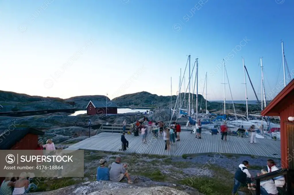People dancing on a pier in an archipelago, Sweden