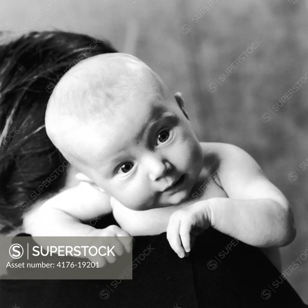 Close-up of a baby girl on her mother's shoulders