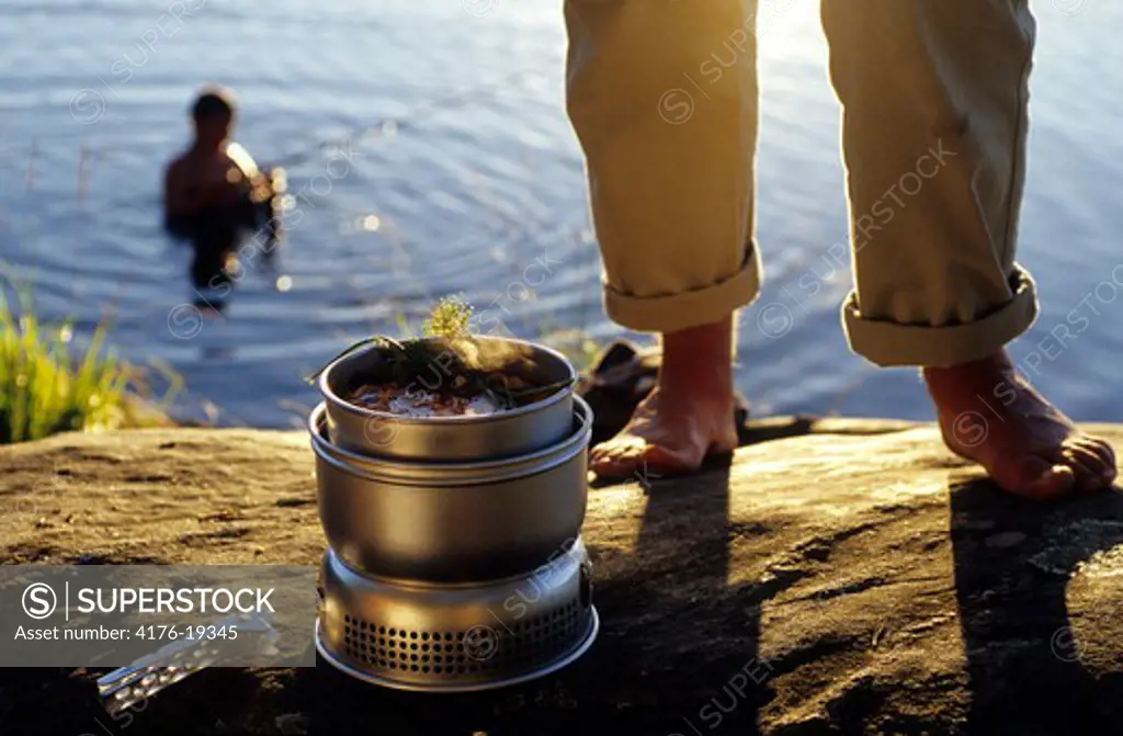 A person cooking by the lake