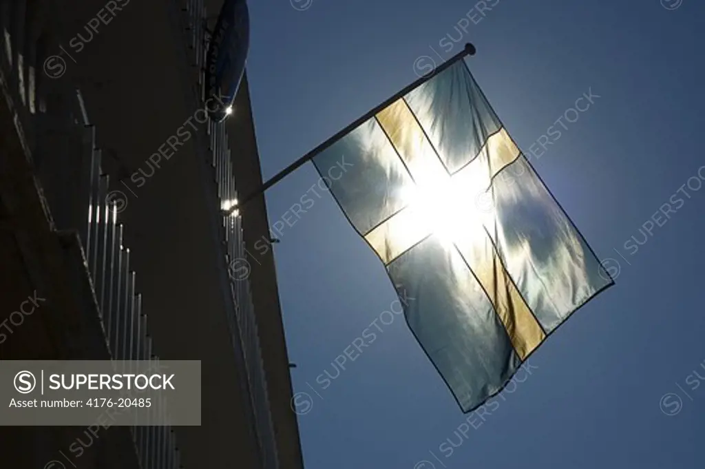 Swedish flag waving with sunlight against blue sky
