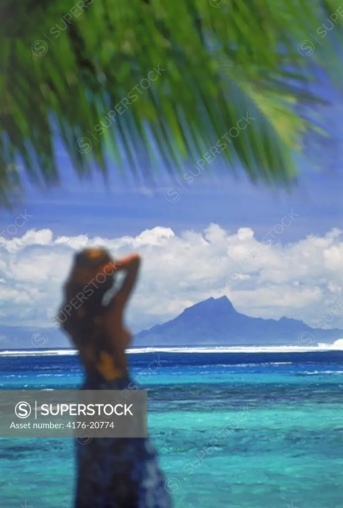 Polynesian on Huahine Island in French Polynesia with Raiatea in distance