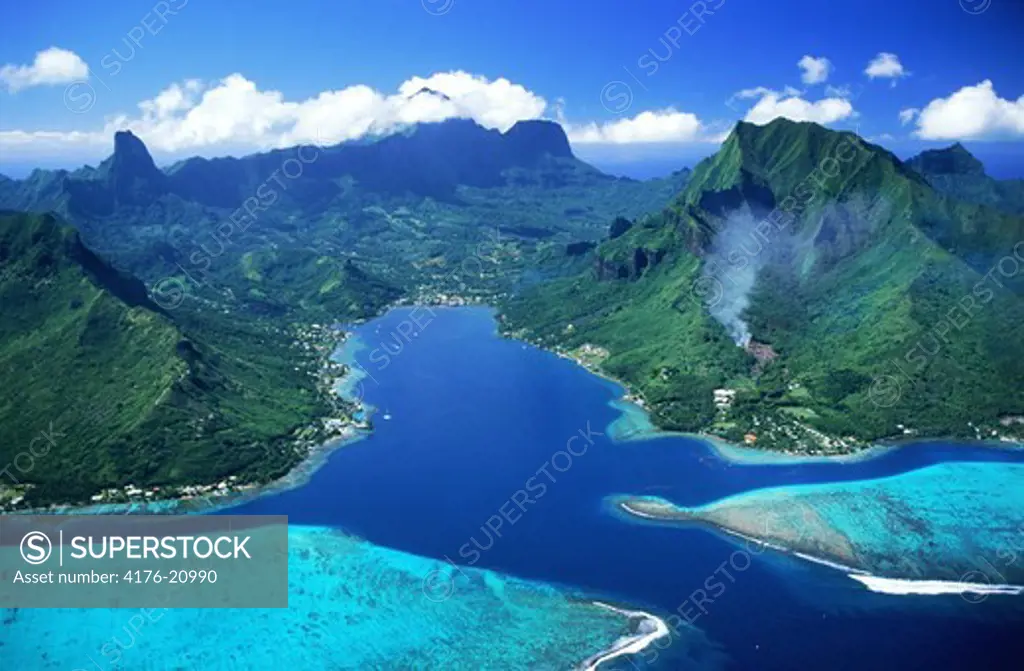 Aerial view of Cooks Bay and mountains on Island of Moorea swimming between blue skies and blue lagoons