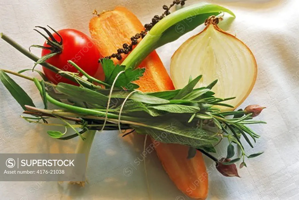 Tomato, carrot, green onion, sage, parsley and pepper on table cloth