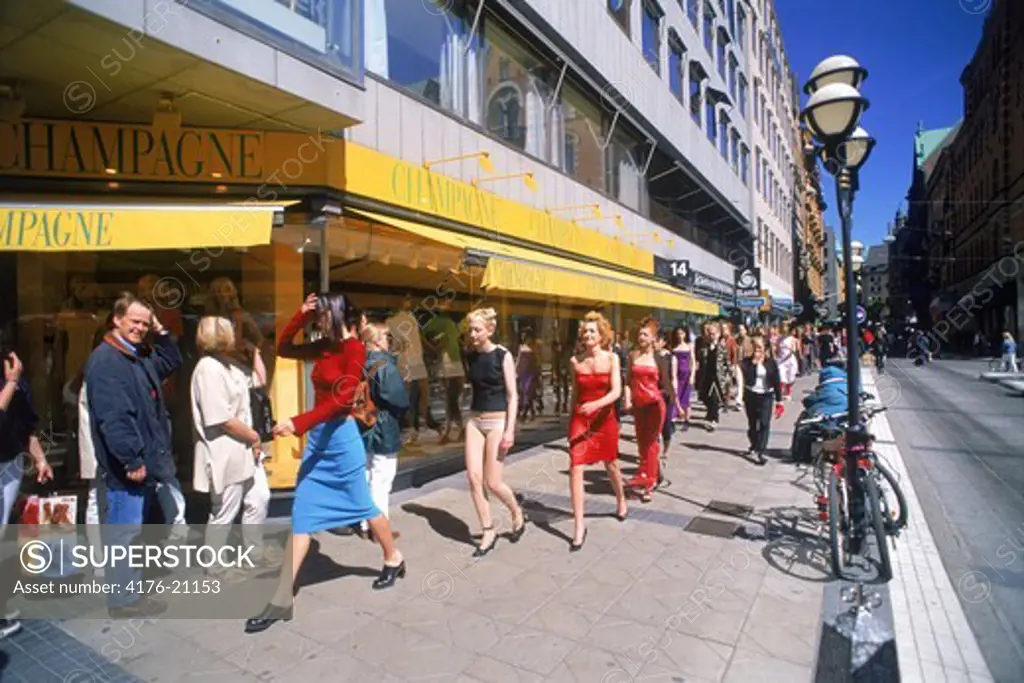 Fashion models and pedistrians on streets of Stockholm at Normalmstorg in summer