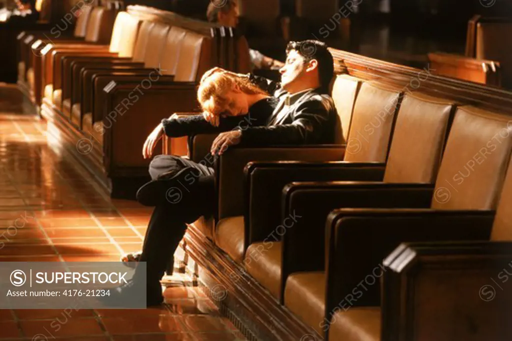 Couple resting in lobby waiting for train at Union Station in Los Angeles