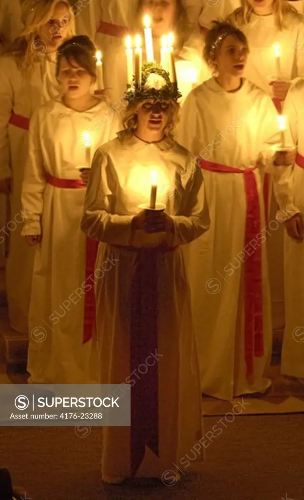 Group of girls standing and holding burning candles on Lucia Day