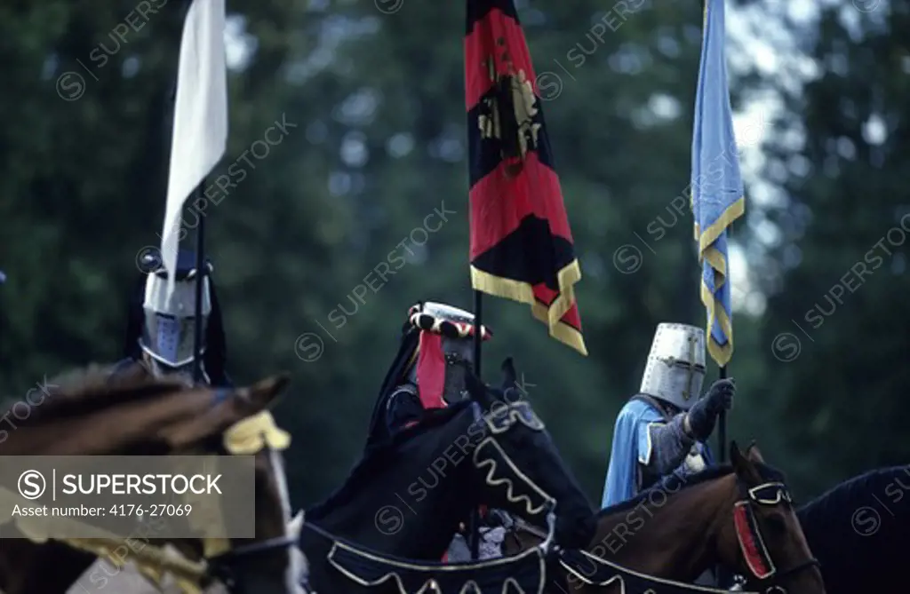 Three men on horses dressed as medieval warriors