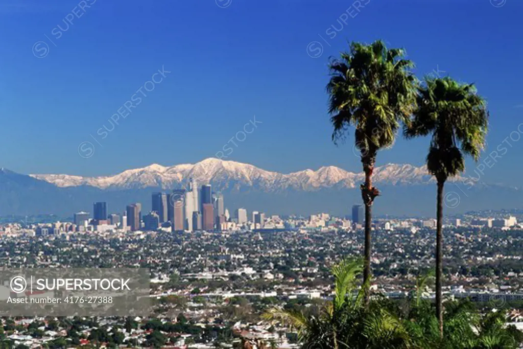 Snow covered San Gabriel Mountains behind downtown Los Angeles skyline