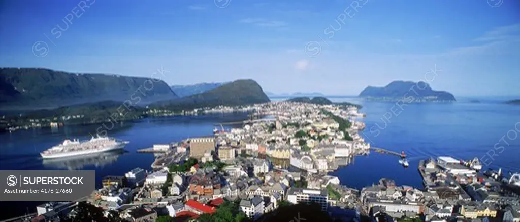 Overview of Alesund on Norwegian coast at dawn with passenger ship entering harbor