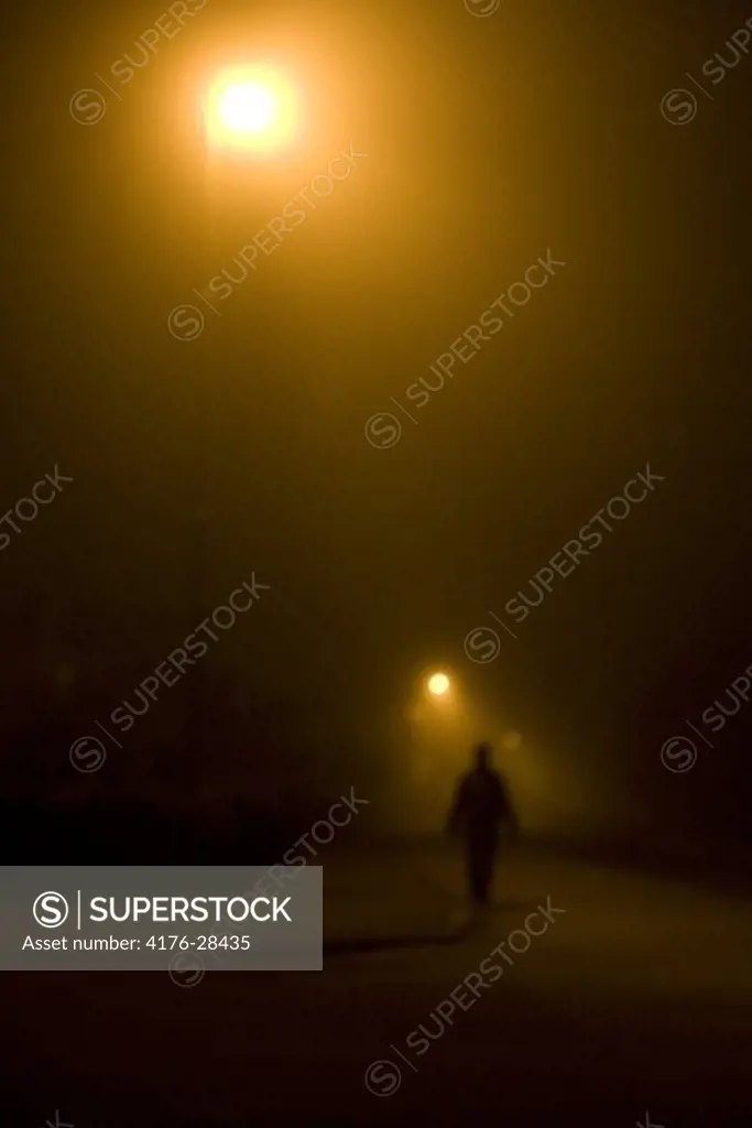 A night lit by streetlight. A person outside walking, Kalmar, Sweden.