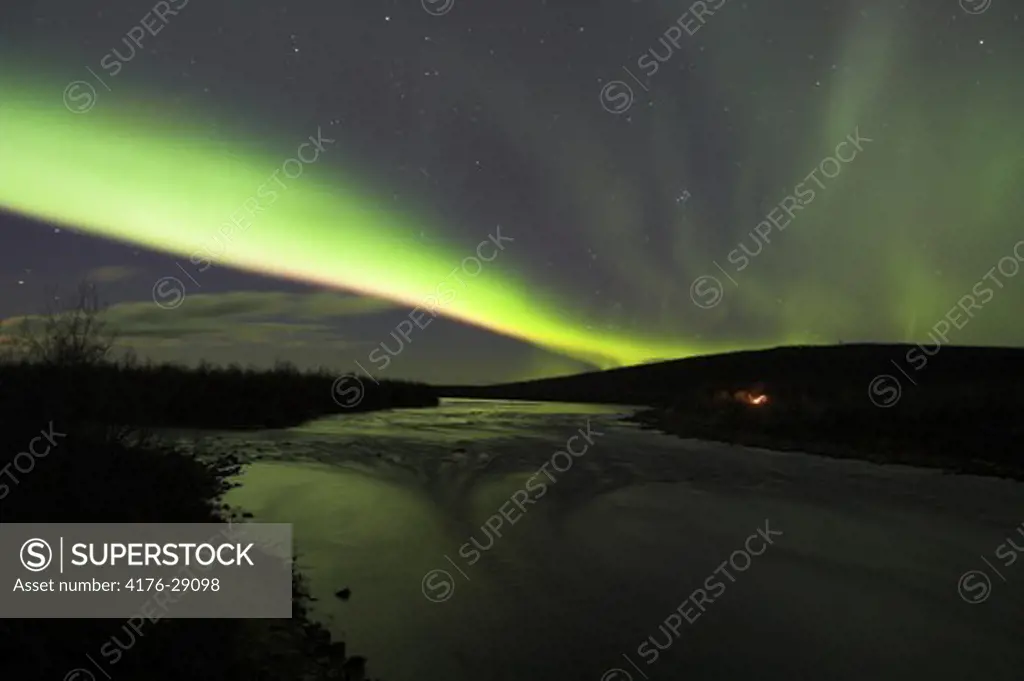 Northern lights over open waters in Lainio River.  Lapland. Sweden
