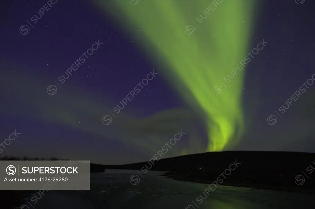 Norther lights over camp by Lainio River on the Swedish Arctic tundra. Lapland. Sweden