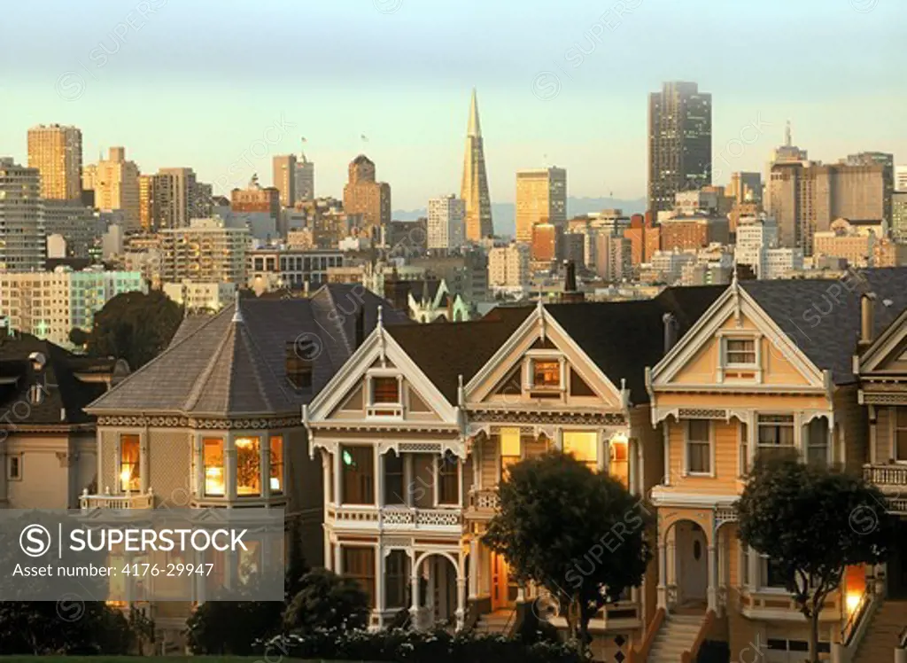 Victorian Houses along Steiner Street at dusk with San Francisco skyline