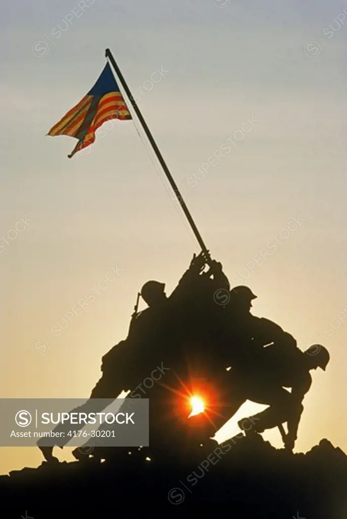 US Marine Corps War Memorial silhouetted in Arlington National Cemetery at sunrise