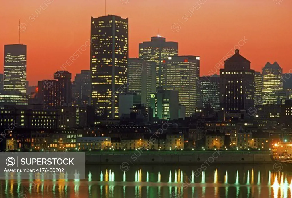 Montreal city skyline reflecting off St Lawrence River at dusk in Quebec, Canada