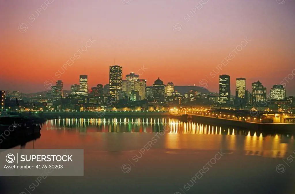 Montreal city skyline reflecting off St Lawrence River at dusk in Quebec, Canada