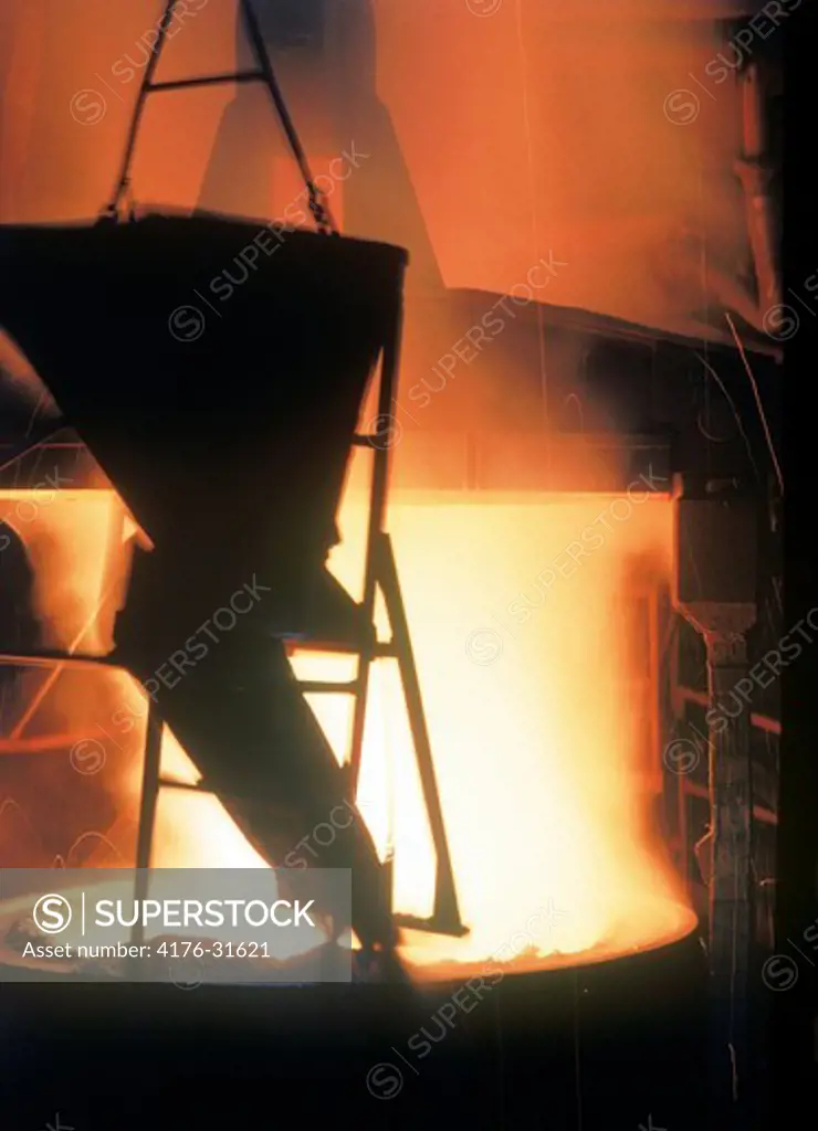 Pouring molten steel from melting pot to ladle
