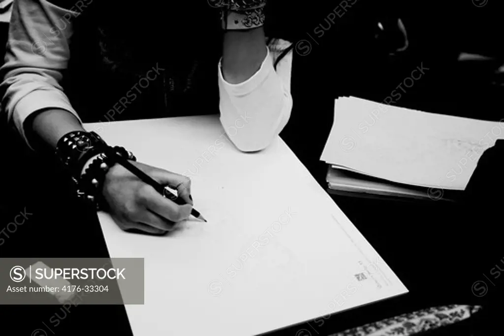 A  women working as a tattoo artist is drawing a sketch for a new tattoo during a tattoo expo in Goteborg (Goteborg) Sweden.