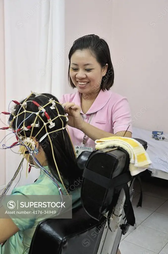 Nurse making a brain examination at a private hospital Hanoi 2008