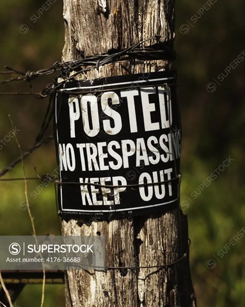Posted, No trespassing, Keep Out sign on a wodden pole in Texas. USA
