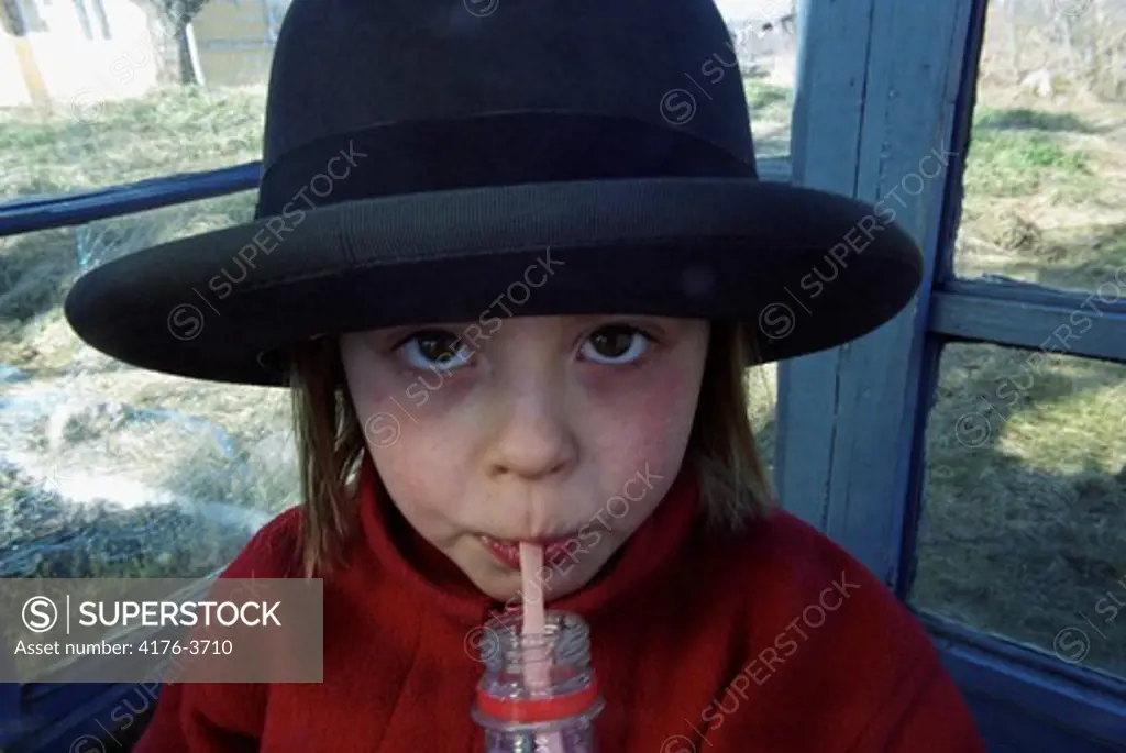 A girl sipping juice through a straw. Sweden