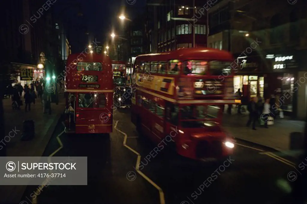 Two double-deckers on a night London street