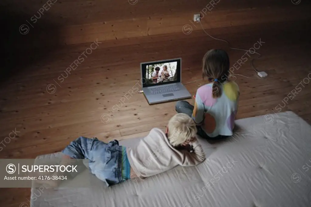 Children watching movie on laptop, Sweden