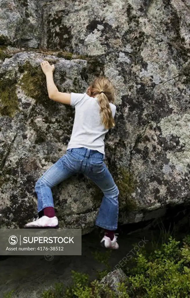 Girl bouldering on a rock, Sweden